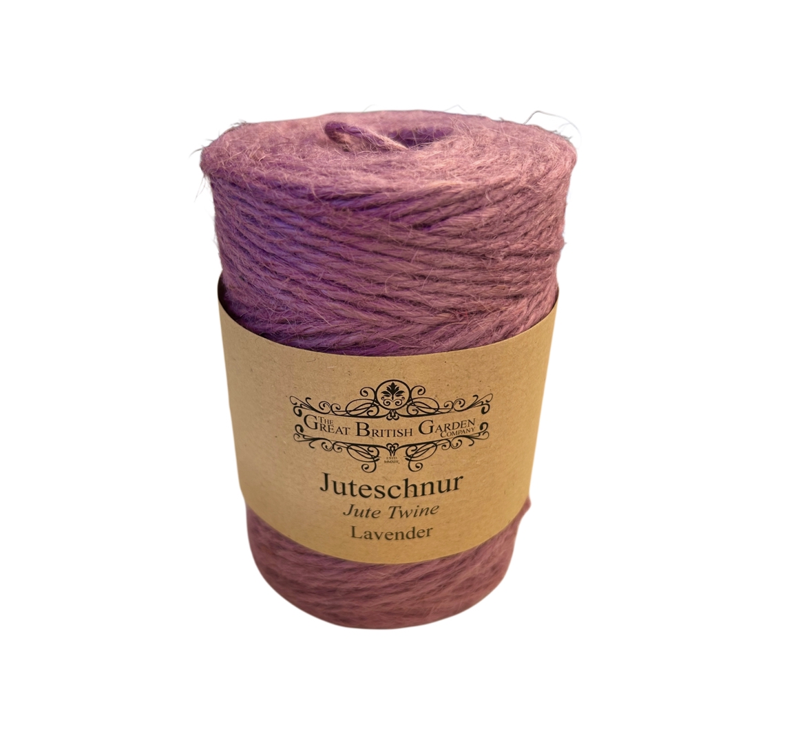 Vertikal stehende Rolle Juteschnur in sanftem Lavendelton, mittig umwickelt von braunem Papieretikett mit Logo der Great British Garden Company und Text „Juteschnur Jute Twine Lavender“. Rau, faserig, fest aufgewickelt.