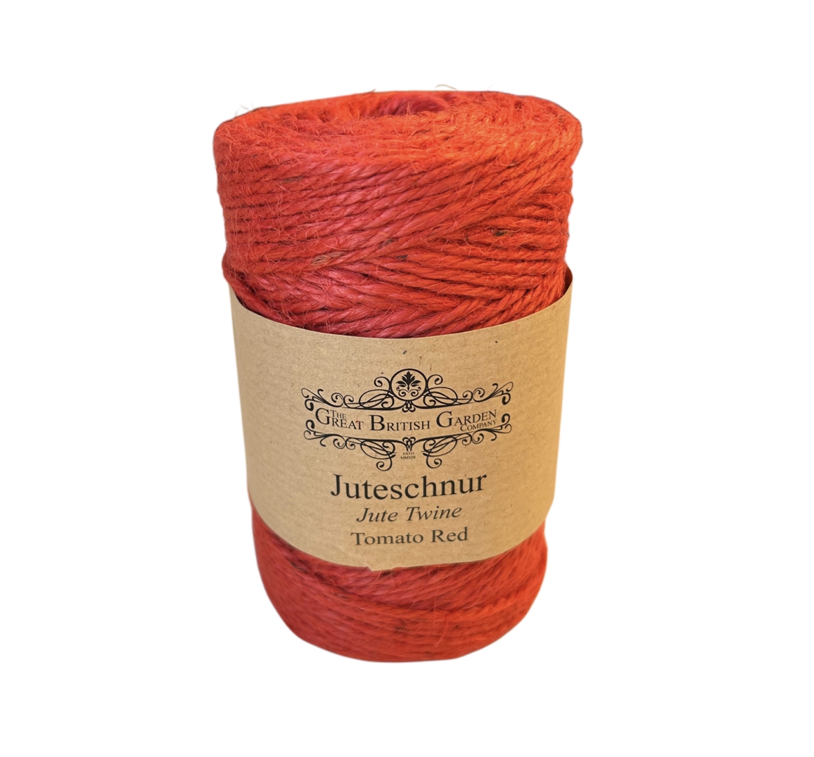 Aufrecht stehendes Bündel tomatenroter Juteschnur. Die feste, natürliche Faser ist gleichmäßig gewickelt. Ein braunes Papierband umschließt die Mitte und zeigt das Logo 'The Great British Garden Company'.
